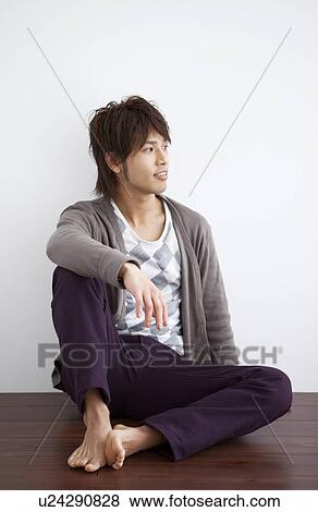 Stock Photo - Young man sitting on floor. Fotosearch