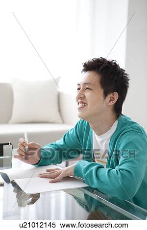 Young man studying at table View Large Photo Image Stock Photography - Young man studying at table. Fotosearch