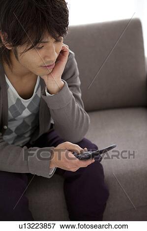 Stock Photo - Young man text messaging. Fotosearch