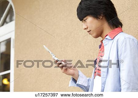 Young man text messaging View Large Photo Image Stock Photo - Young man text messaging. Fotosearch