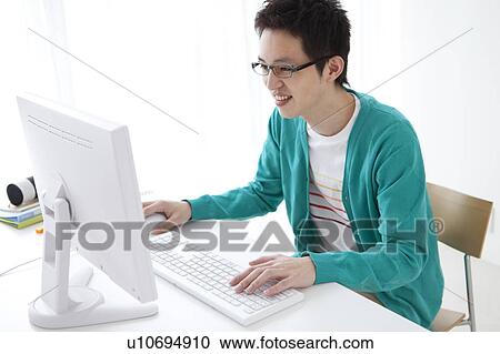Young man using desktop PC View Large Photo Image Stock Image - Young man using desktop PC. Fotosearch