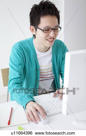 Young man using desktop PC View Large Photo Image Stock Photograph - Young man using desktop PC. Fotosearch