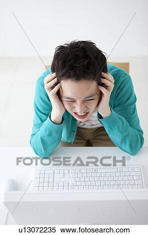 Young man using desktop PC View Large Photo Image Stock Photography - Young man using desktop PC. Fotosearch