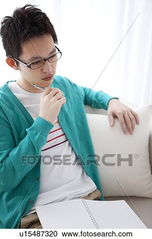 Stock Image - Young man with hand on chin. Fotosearch