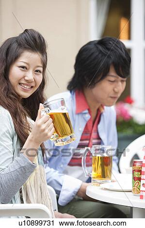 Stock Image - Young people eating at an outdoor cafe. Fotosearch