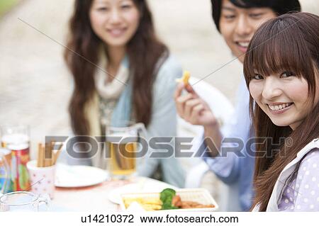 Young people eating at an outdoor cafe View Large Photo Image Stock Image - Young people eating at an outdoor cafe. Fotosearch