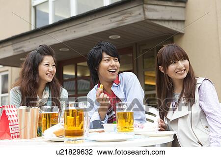 Young people eating at an outdoor cafe View Large Photo Image Stock Image - Young people eating at an outdoor cafe. Fotosearch