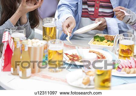 Young people eating at an outdoor cafe View Large Photo Image Stock Photo - Young people eating at an outdoor cafe. Fotosearch