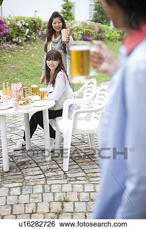 Stock Photograph - Young people eating outdoors. Fotosearch