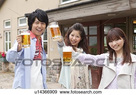 Stock Photo - Young people toasting with beer. Fotosearch