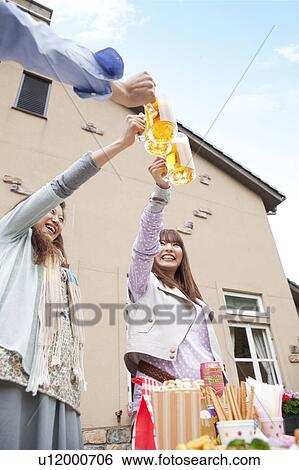 Stock Photograph - Young people toasting with beer. Fotosearch