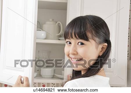 Young Woman at Cupboard View Large Photo Image Stock Image - Young Woman at Cupboard. Fotosearch