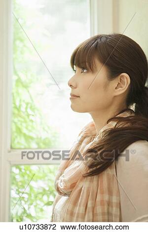 Stock Image - Young Woman by Window. Fotosearch