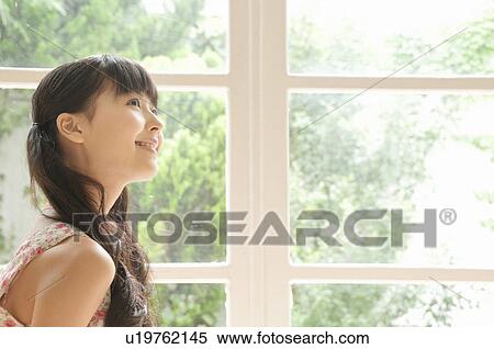 Stock Photography - Young Woman by Window. Fotosearch