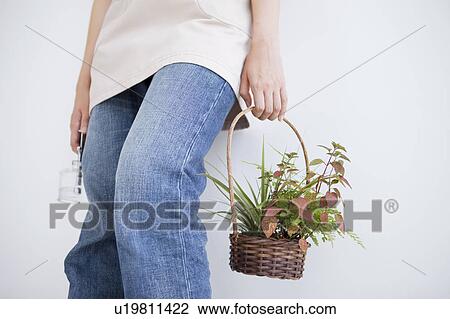 Young woman holding spray bottle and potted plant View Large Photo Image Stock Image - Young woman holding spray bottle and potted plant. Fotosearch