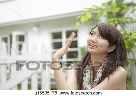 Young Woman Looking Up at Sky and Waving Hand View Large Photo Image Stock Photo - Young Woman Looking Up at Sky and Waving Hand. Fotosearch