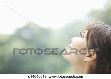 Stock Image - Young Woman Looking Up. Fotosearch