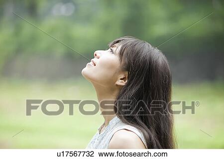 Stock Image - Young Woman Looking Up. Fotosearch