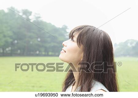 Stock Image - Young Woman Looking Up. Fotosearch