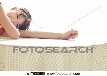 Stock Image - Young Woman Lying on Table. Fotosearch