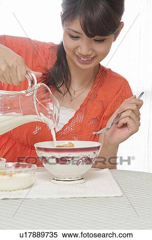 Young Woman Pouring Milk Over Cereals View Large Photo Image Stock Photography - Young Woman Pouring Milk Over Cereals. Fotosearch