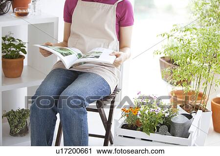 Stock Image - Young woman reading a book. Fotosearch