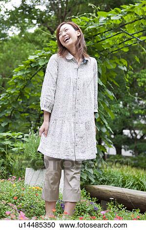 Young woman standing and smiling View Large Photo Image Stock Image - Young woman standing and smiling. Fotosearch