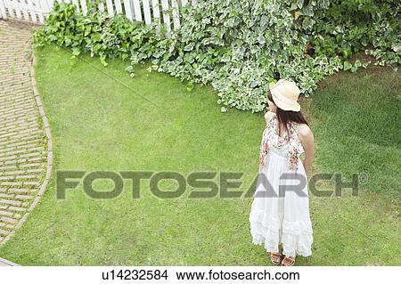Picture - Young Woman Standing on Grass. Fotosearch