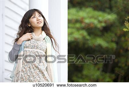 Young woman standing outdoors View Large Photo Image Stock Image - Young woman standing outdoors. Fotosearch