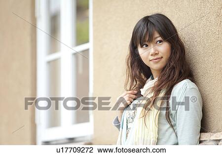 Stock Image - Young woman standing outdoors. Fotosearch
