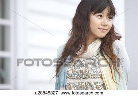 Stock Photo - Young woman standing outdoors. Fotosearch