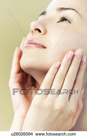 Young woman touching face View Large Photo Image Picture - Young woman touching face. Fotosearch