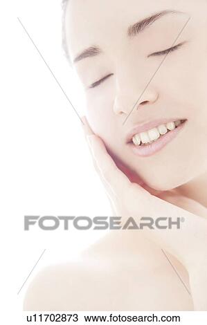 Stock Image - Young woman touching face. Fotosearch