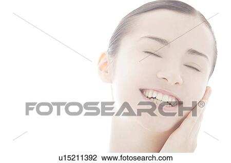 Young woman touching face View Large Photo Image Stock Image - Young woman touching face. Fotosearch