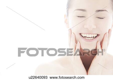 Stock Image - Young woman touching face. Fotosearch