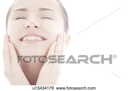 Young woman touching face View Large Photo Image Stock Photo - Young woman touching face. Fotosearch