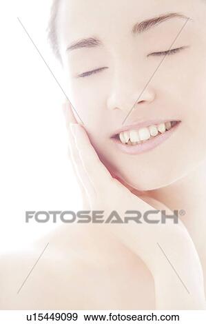 Young woman touching face View Large Photo Image Stock Photo - Young woman touching face. Fotosearch