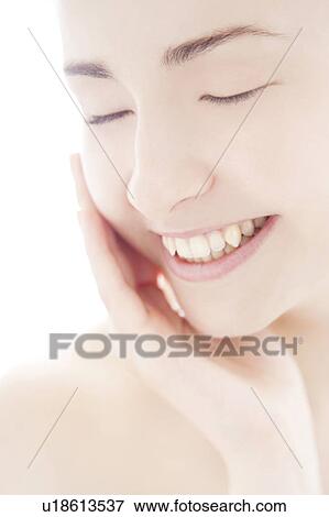 Young woman touching face View Large Photo Image Stock Photo - Young woman touching face. Fotosearch