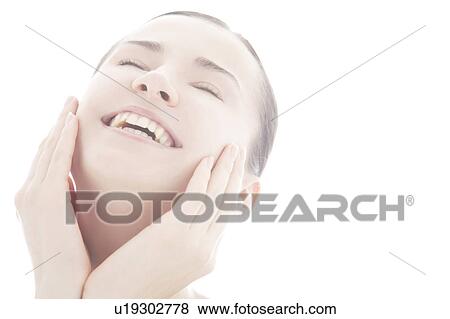 Young woman touching face View Large Photo Image Stock Photo - Young woman touching face. Fotosearch