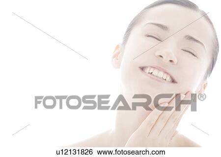 Stock Photograph - Young woman touching face. Fotosearch