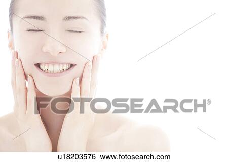 Young woman touching face View Large Photo Image Stock Photograph - Young woman touching face. Fotosearch