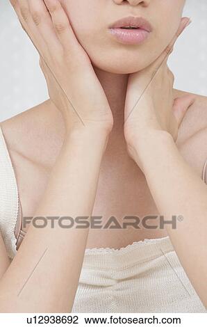 Stock Image - Young Woman Touching Her Face. Fotosearch