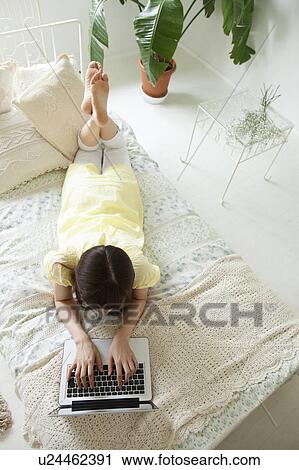 Stock Image - Young Woman Typing with Laptop. Fotosearch
