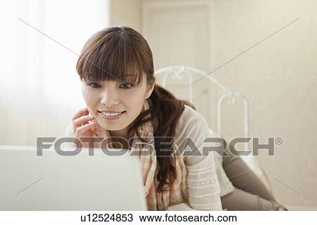 Young Woman Using Laptop in Bedroom View Large Photo Image Stock Image - Young Woman Using Laptop in Bedroom. Fotosearch