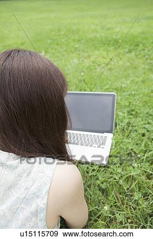 Young Woman Using Laptop on Grass View Large Photo Image Stock Photo - Young Woman Using Laptop on Grass. Fotosearch