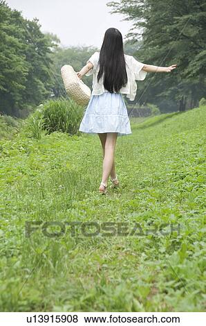 Stock Photo - Young Woman Walking in Park. Fotosearch