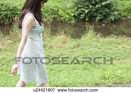 Young Woman Walking on Grass View Large Photo Image Stock Photo - Young Woman Walking on Grass. Fotosearch