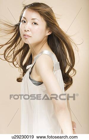 Young woman with hair flowing View Large Photo Image Stock Photo - Young woman with hair flowing. Fotosearch