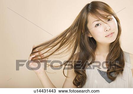 Young woman with hand in hair View Large Photo Image Stock Image - Young woman with hand in hair. Fotosearch