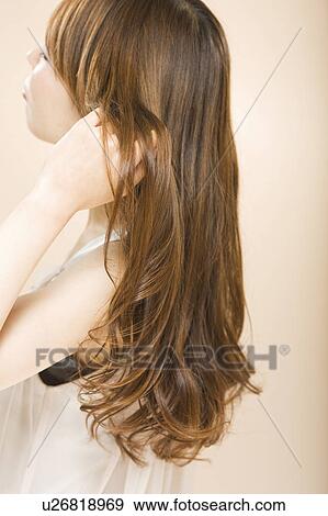 Young woman with hand in hair View Large Photo Image Stock Photo - Young woman with hand in hair. Fotosearch